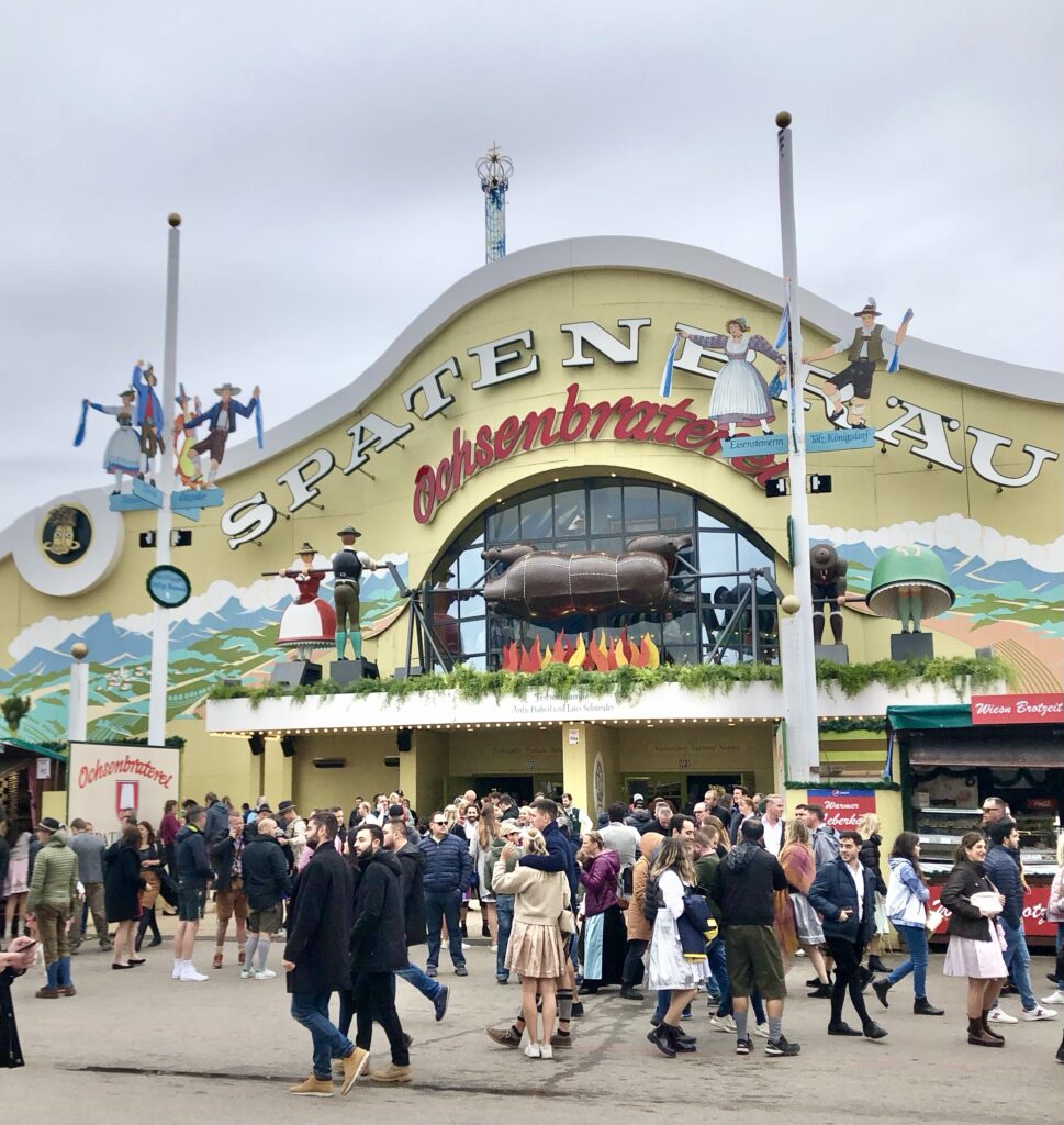 oktoberfest entrance , people walking in dirndl and lederhosen 