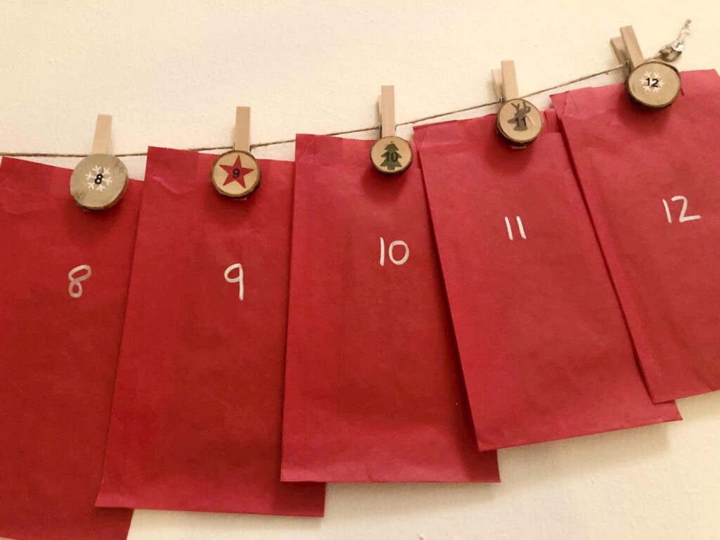 Red bags numbered hung by twine forming an advent calendar