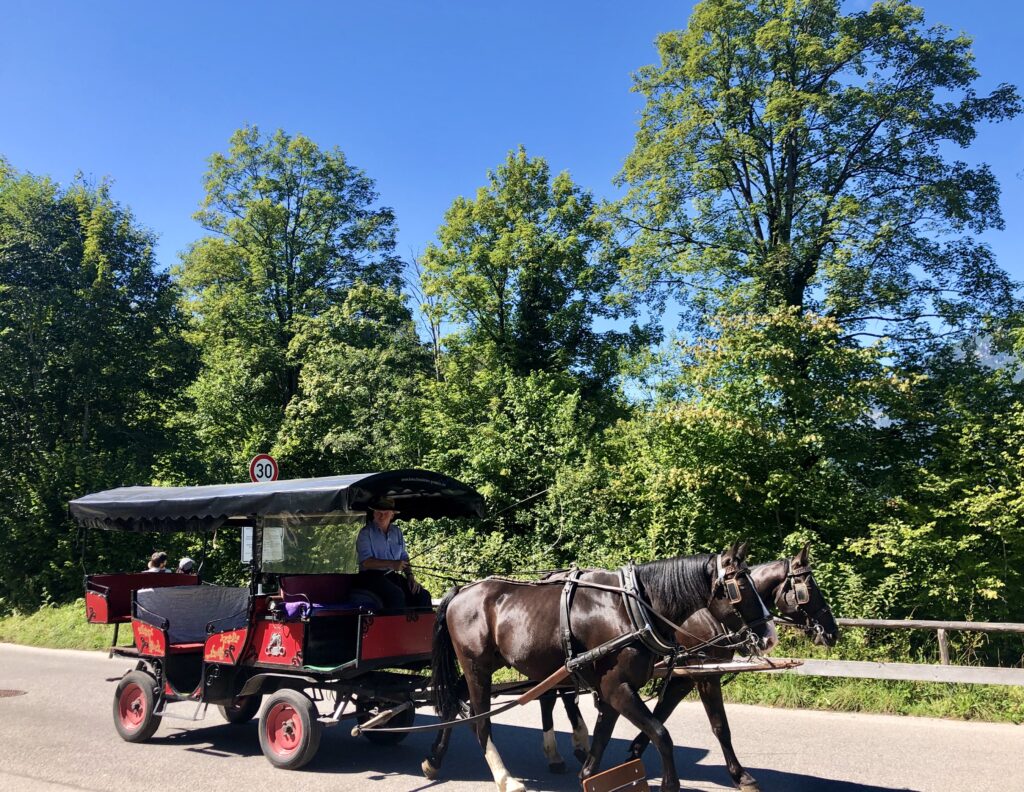 A horse drawn carriage carrying visitors to the entrance gate of the Partnach Gorge in Bavaria, Germany. 