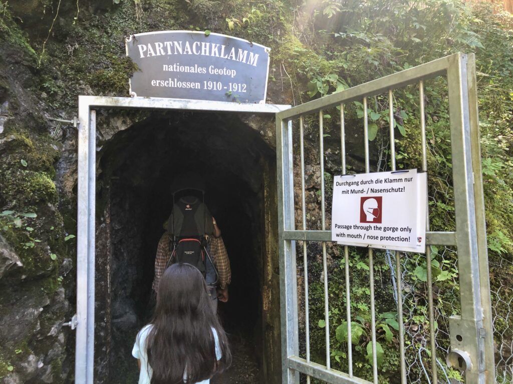 A family entering the steel gate to Germany's Partnachklamm hike. 